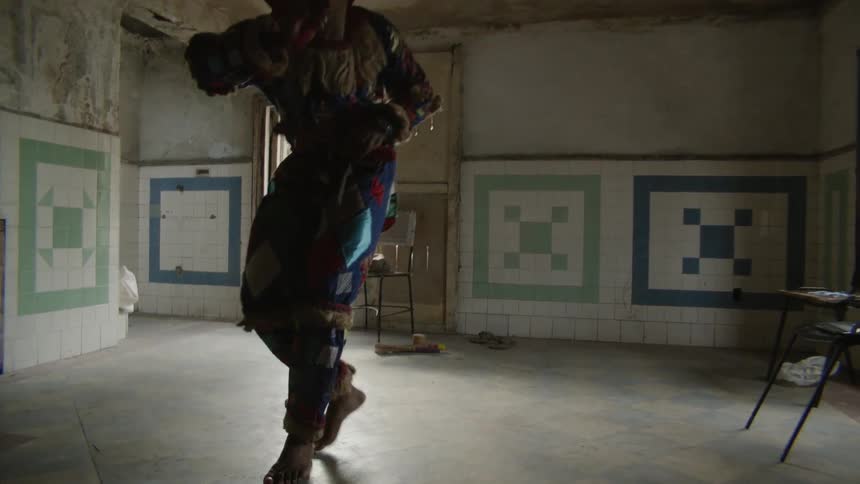 Man in a costume dances indoors