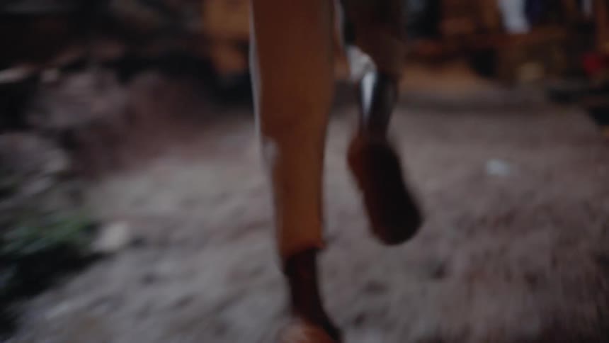 Someone runs at night along a dirt street