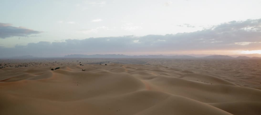 The sun is setting over the vast desert