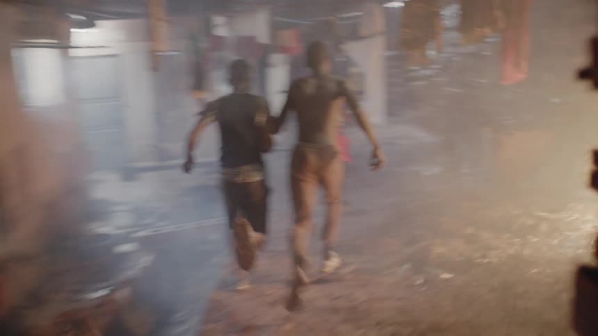 A group of boys are chasing another boy through a neighborhood at night