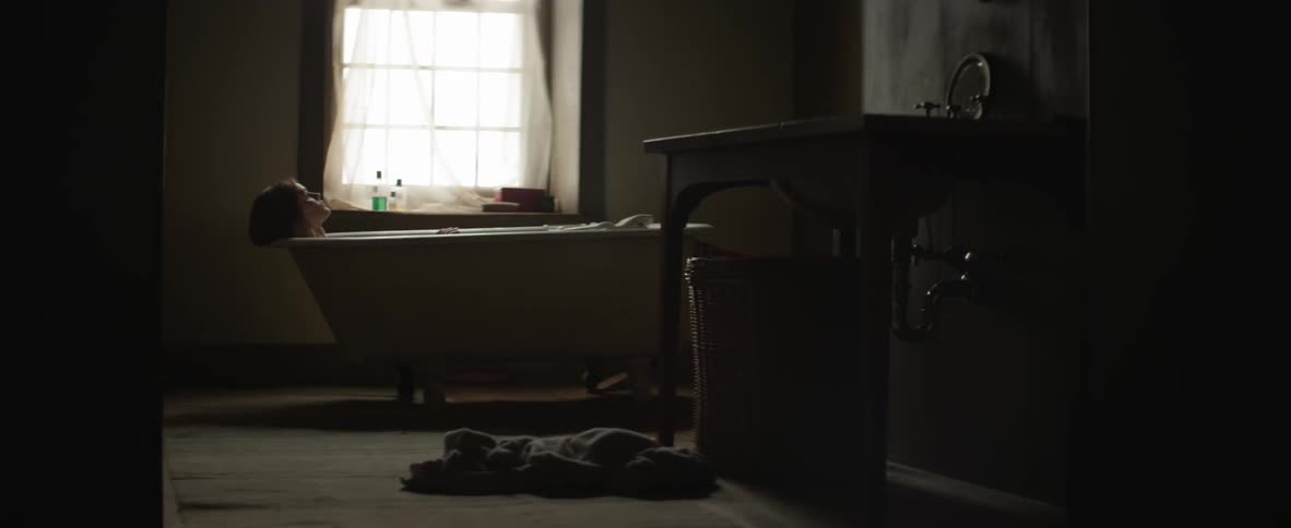 Woman taking a bath by a window
