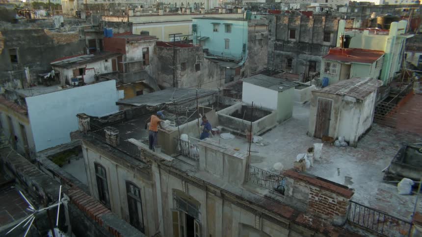 Men stand on a building rooftop