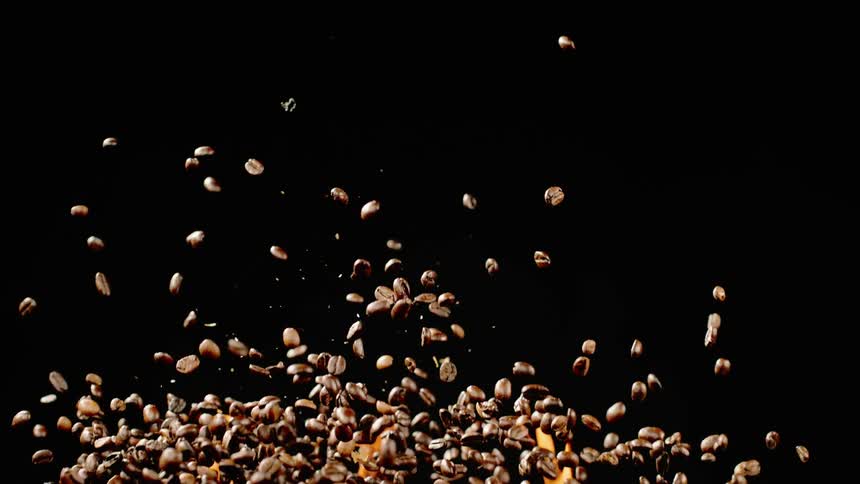 Coffee beans fly through the air in front of flames