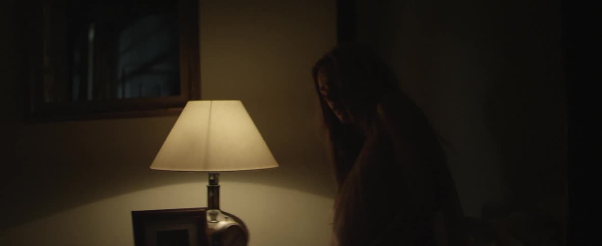 A pregnant woman turning on a lamp and getting out of bed