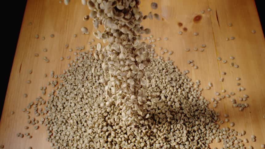 Coffee beans fall onto a table
