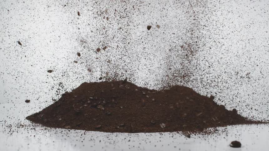The coffee grounds explode rising into the air