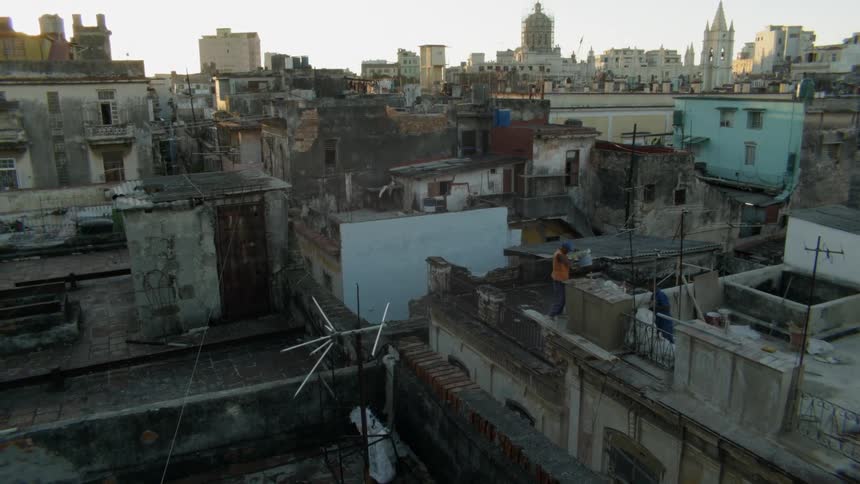 Man stands on a rooftop in a city