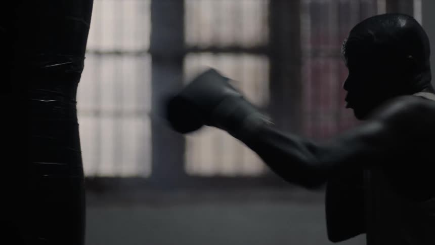 A man trains on a heavy punching bag