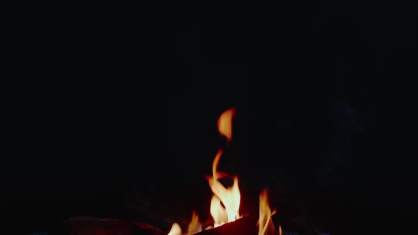 A fire burns in the dark