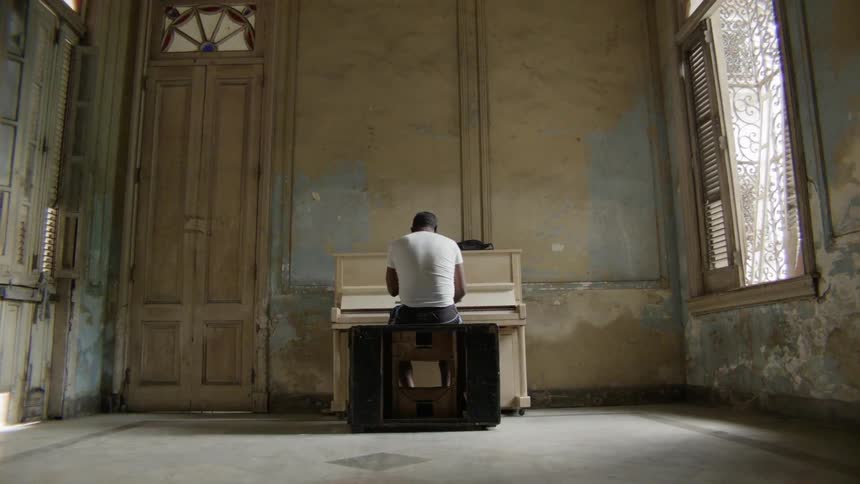 A man is playing the piano near the door