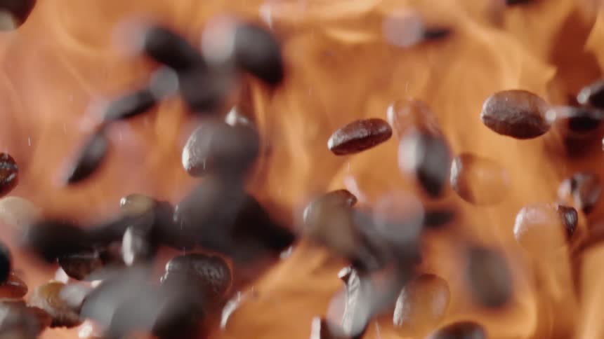 Coffee beans falling and fire blazes behind it