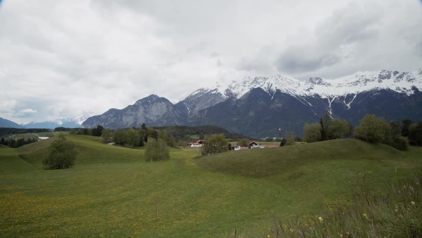 The green hills lead to the snow covered mountain