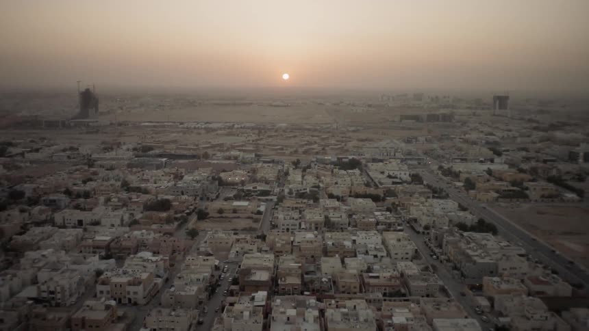 Riyadh Sunrise - The sun is rising over a sprawling urban area on dusty day