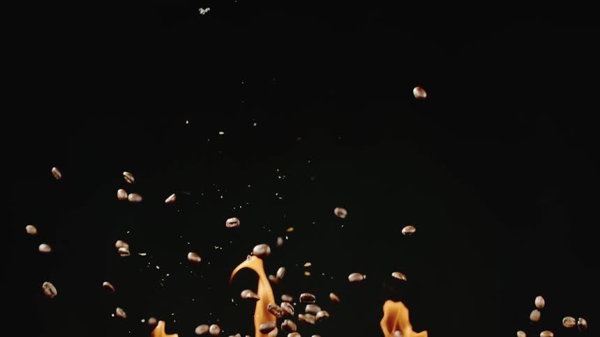 Coffee beans are falling through flames and being roasted