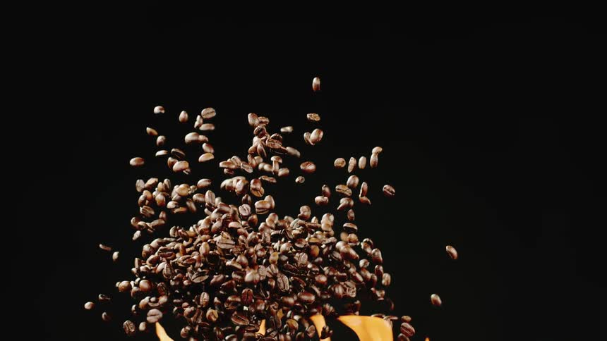 Coffee beans fly in the air above a flame against a black background