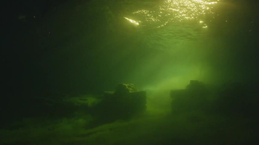 An oar displaces water on the surface while items sit on the bottom