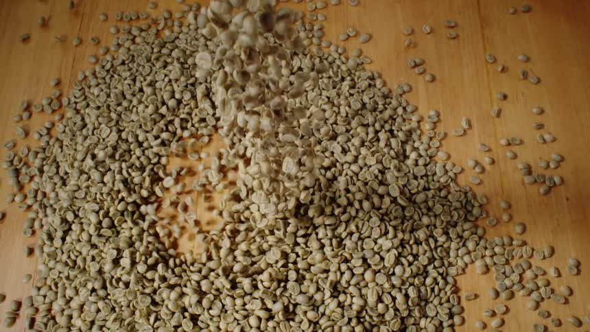 Coffee beans fall onto a table