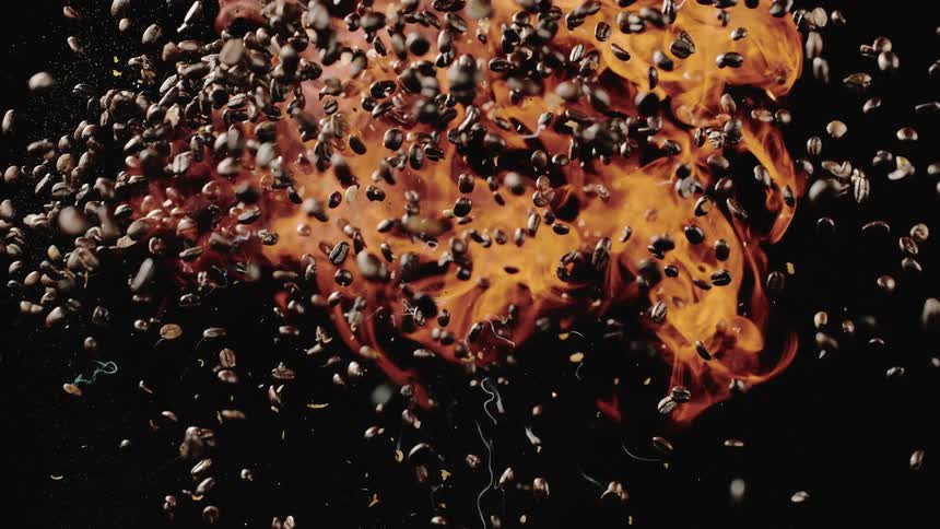 Coffee beans fall as flames roll behind them