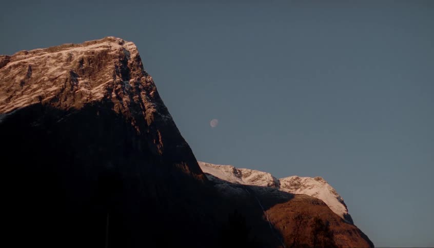 Late afternoon moon hovers behind mountain