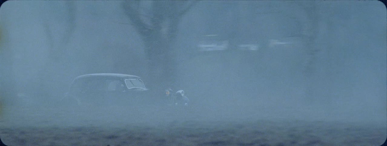 Old car traveling on country road on rainy evening