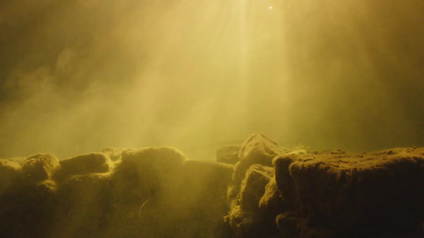 The sun shines on the rocks underwater