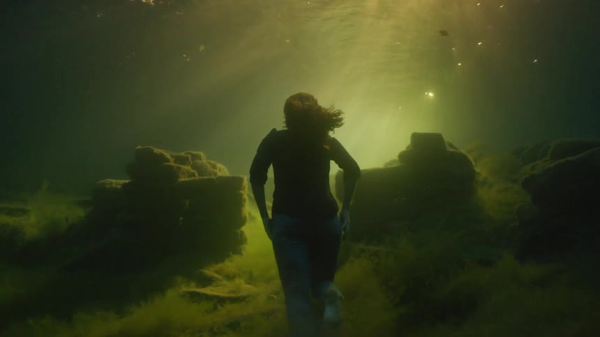 The woman is running at the bottom of the water
