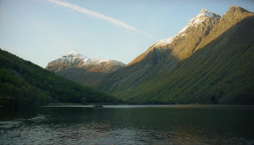 The water is calm in the lake by the mountain
