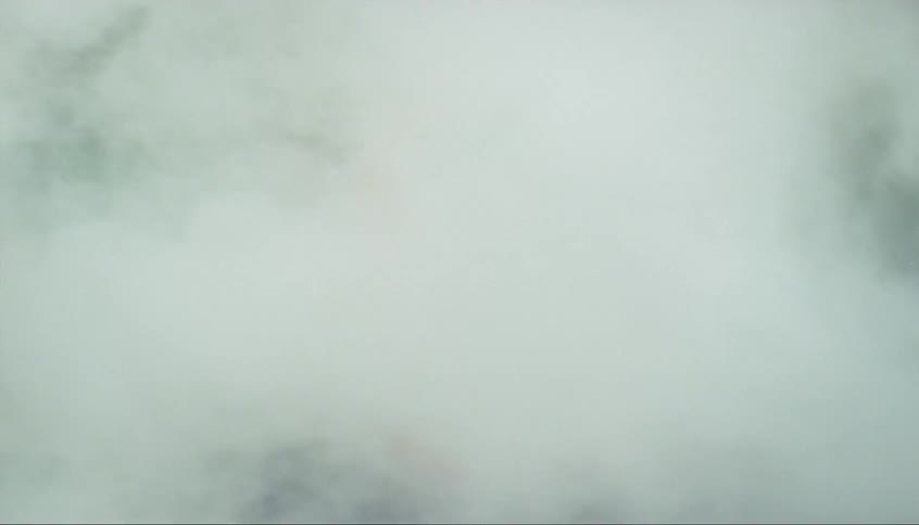 Clouds of smoke float in front of a man