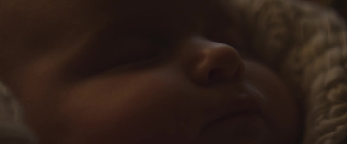 A baby sleeps and moves his mouth while laying down