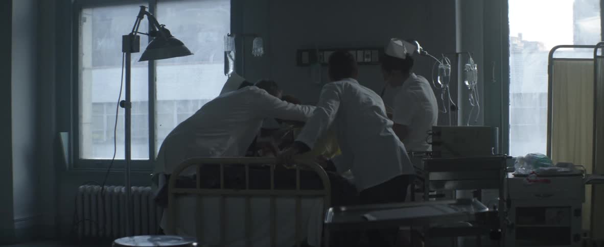 Hospital staff work with a patient in bed