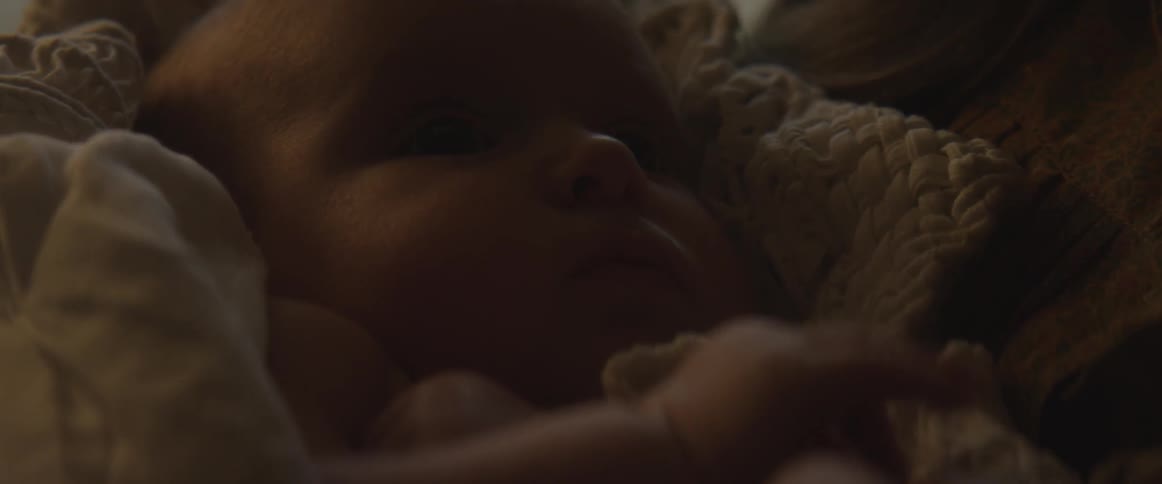 A baby is cradled in a blanket