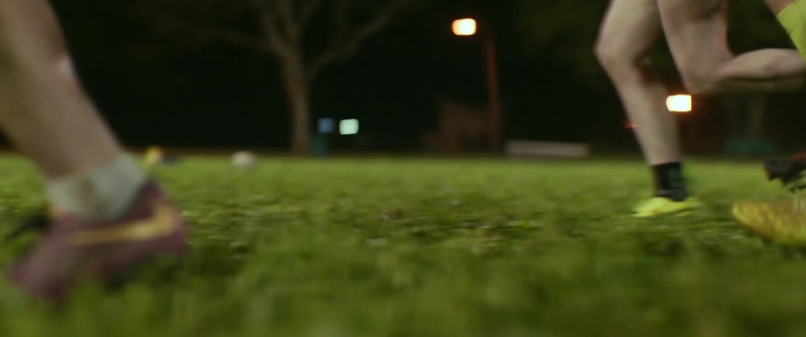 A group of athletes run in cleats on the field