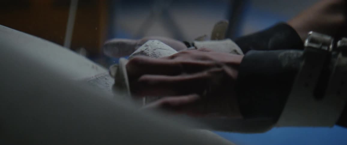 A gymnast is rubbing powder onto her hands and braces