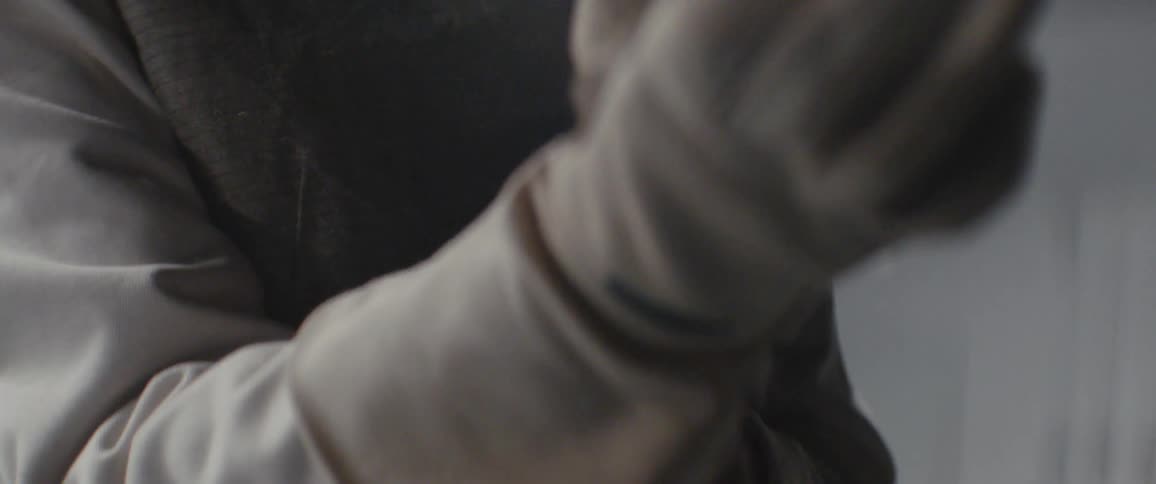 Person puts gloves on while wearing a uniform