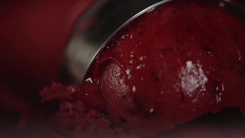 The red ice cream is being scooped