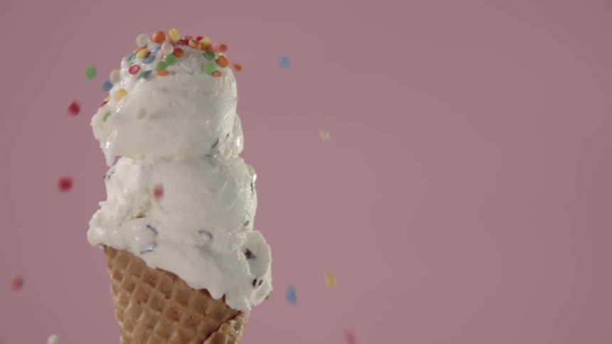 Sprinkles fall onto an ice cream cone
