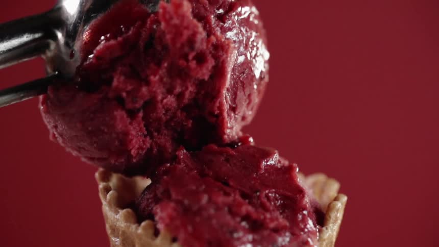 The cone is filled with red ice cream