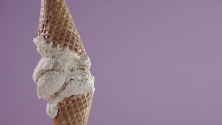 A second cone is put on top of an ice cream cone with three scoops