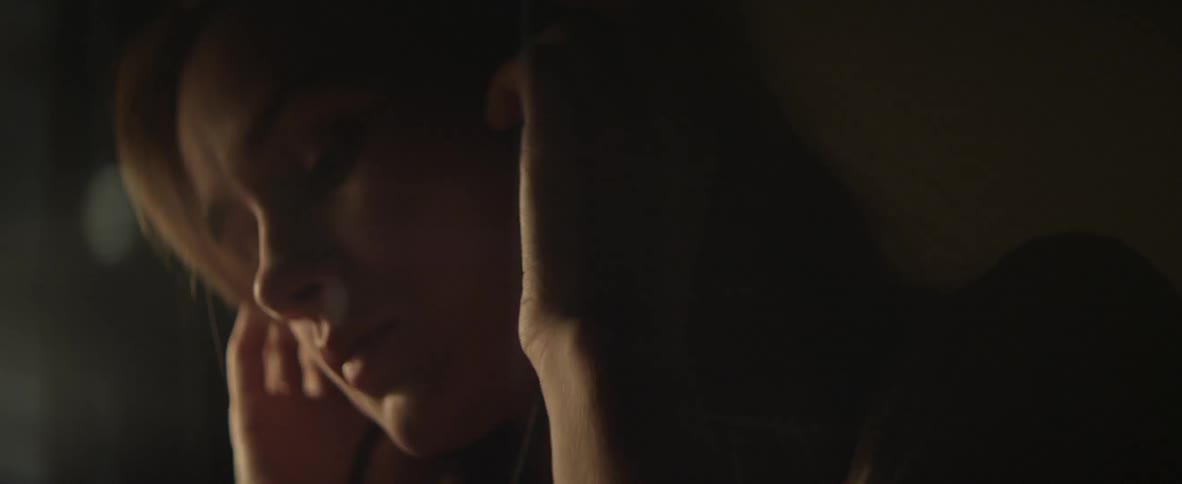 A woman holds her hands to her ears