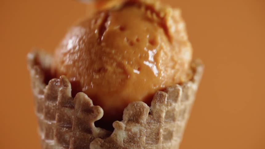 Ice cream scoop falls into an ice cream cone