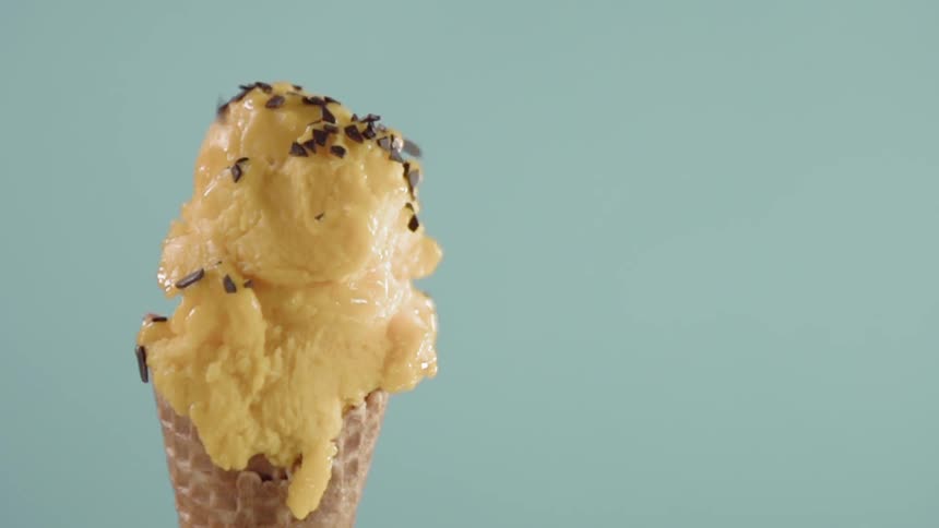 Sprinkles fall onto an ice cream cone