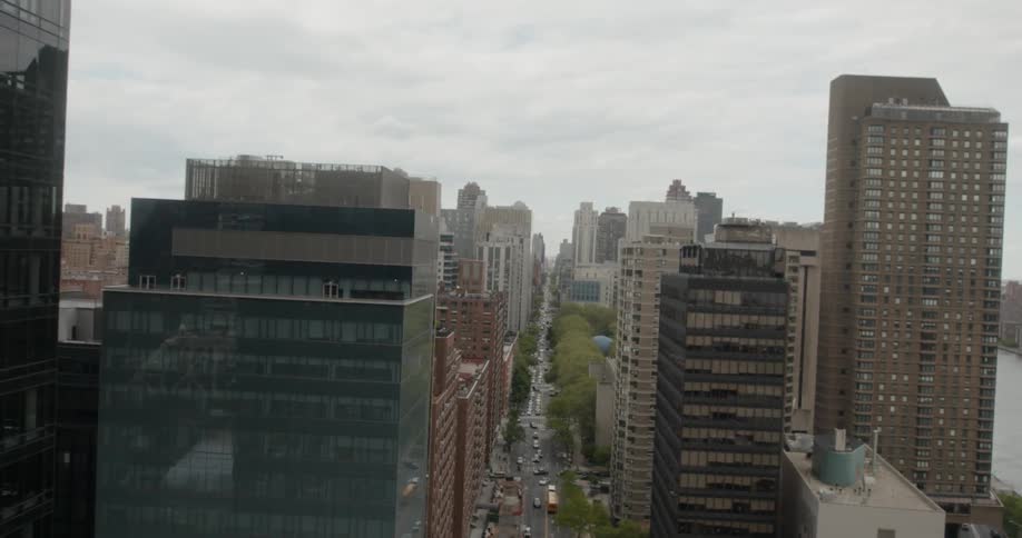 Cars travel down the avenue of the city