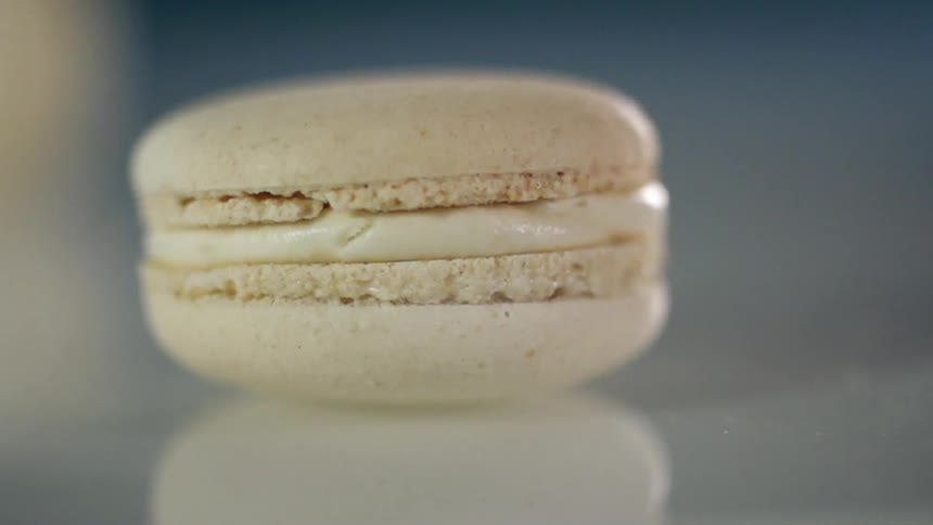 The white macaroon spins on the table