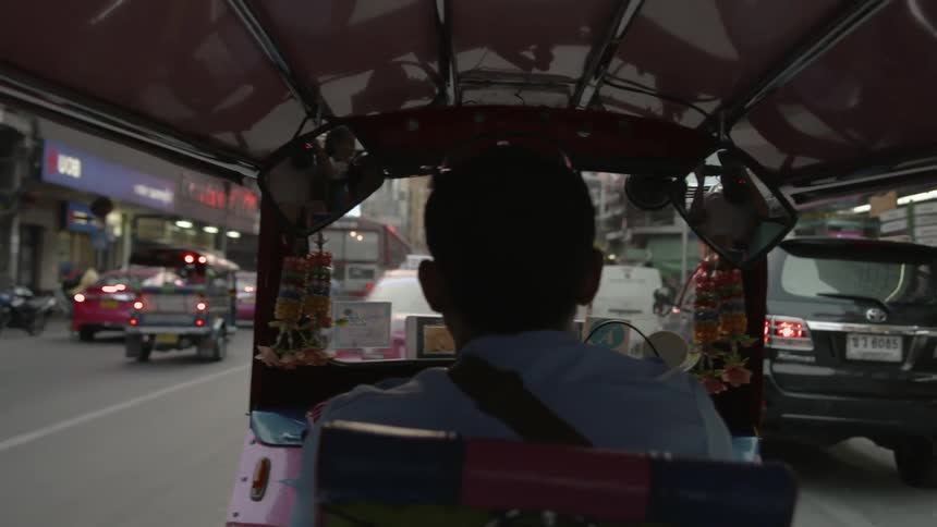 A man is steering the vehicle on the crowded street