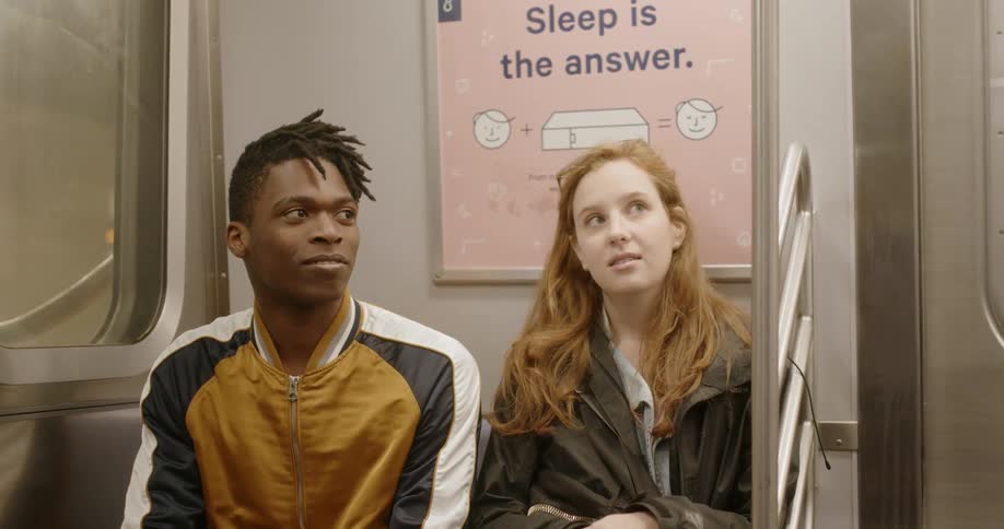 A man and woman ride the train together