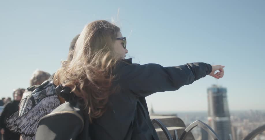 A woman points out something on the rooftop