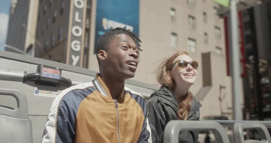 A man and woman take in the sites on a tour bus