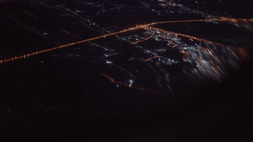 The road is brightly lit at night below