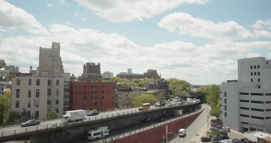 The vehicles travel on the freeway around the buildings