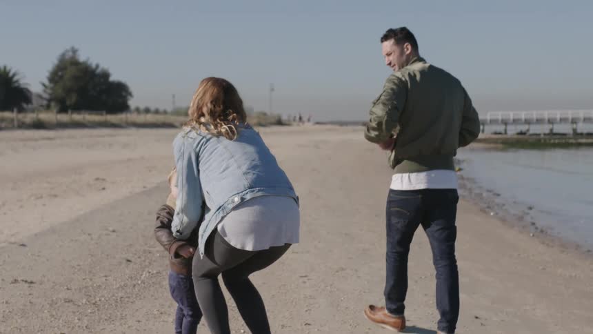 Family At Beach With Their Toddler